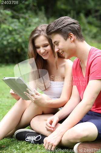 Image of Young teenage friends sharing a tablet-pc