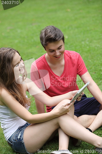 Image of Smiling young girl and boy reading a tablet