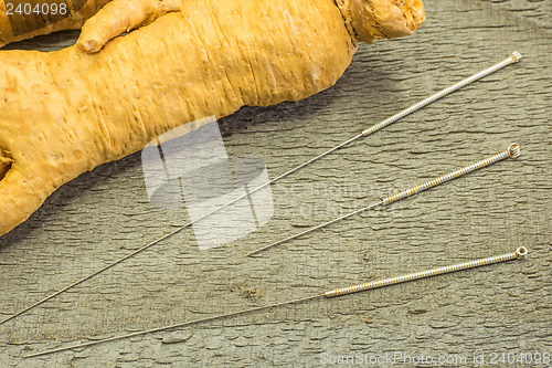 Image of acupuncture needles and ginseng root