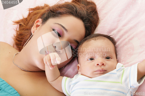 Image of Hispanic mother kissing her baby hand.  Focus on the mother.