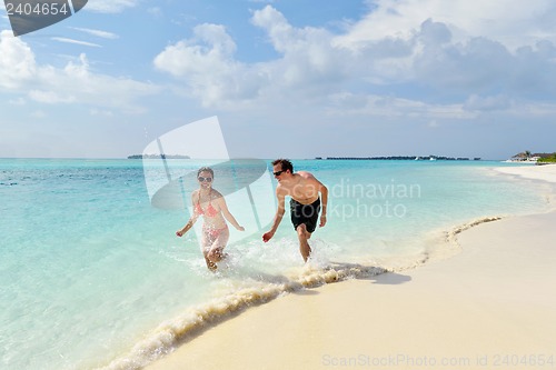 Image of happy young couple have fun on beach