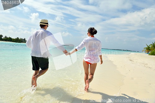 Image of happy young couple have fun on beach