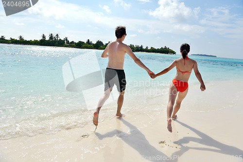 Image of happy young couple have fun on beach