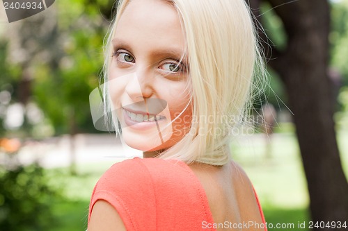 Image of beautiful young blonde girl lying in grass summertime