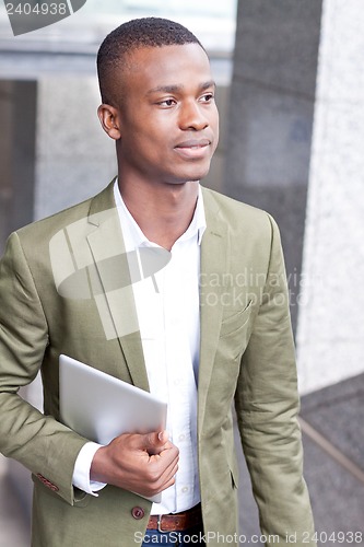 Image of smiling successful businessman with tablet pc outdoor