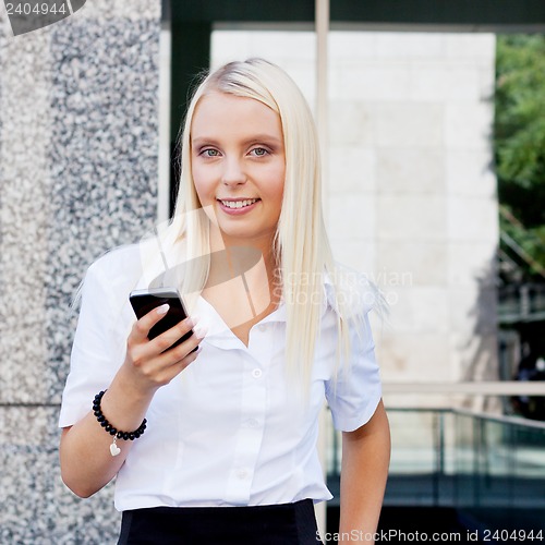 Image of smiling attractive blonde businesswoman with smartphone 