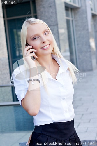 Image of smiling attractive blonde businesswoman with smartphone 