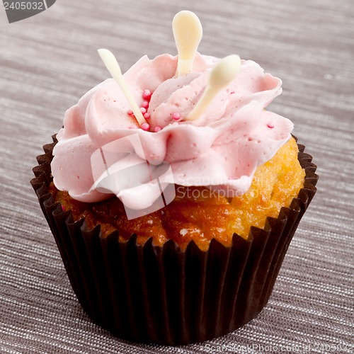Image of tasty sweet homemade cupcakes with cream on table