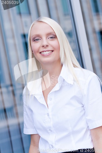 Image of attractive young successful smiling business woman standing outdoor 