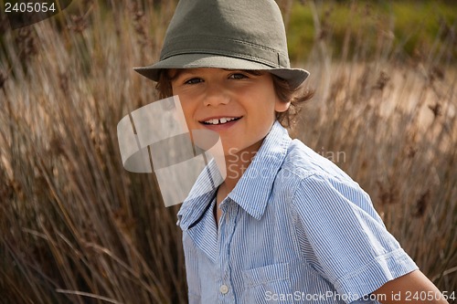 Image of cute little boy playing in sand on beach in summer