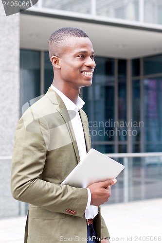 Image of smiling successful businessman with tablet pc outdoor