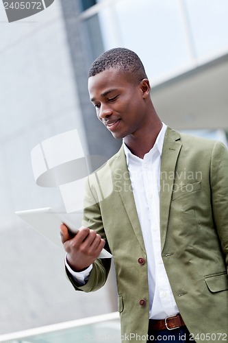 Image of smiling successful businessman with tablet pc outdoor