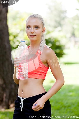 Image of attractive young blonde woman drinking water outdoor sport