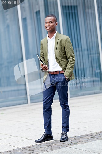 Image of smiling successful businessman with tablet pc outdoor