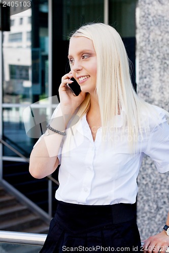 Image of smiling attractive blonde businesswoman with smartphone 