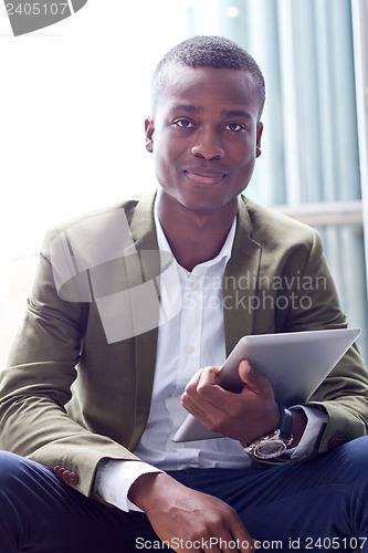 Image of smiling successful businessman with tablet pc outdoor