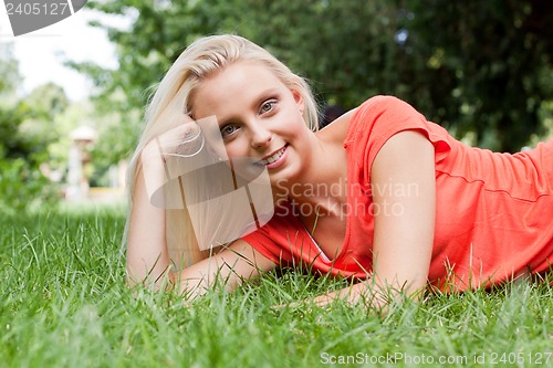 Image of beautiful young blonde girl lying in grass summertime