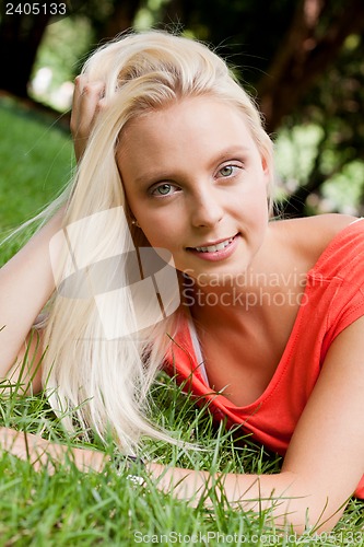 Image of beautiful young blonde girl lying in grass summertime