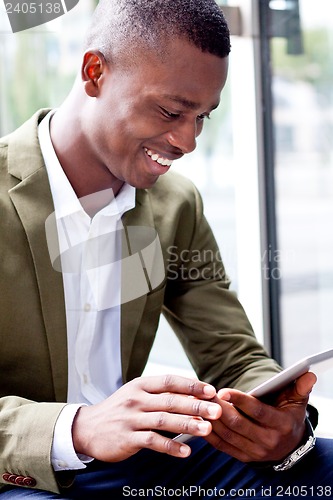 Image of smiling successful businessman with tablet pc outdoor