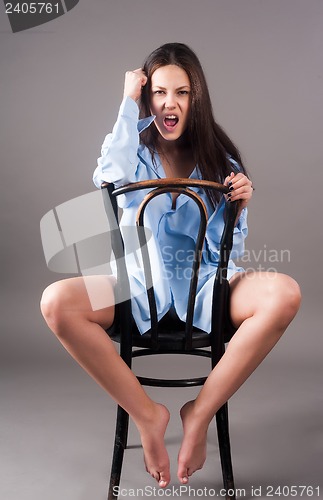 Image of Young crying woman on chair