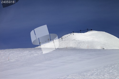 Image of Ski slope and ropeway against blue sky