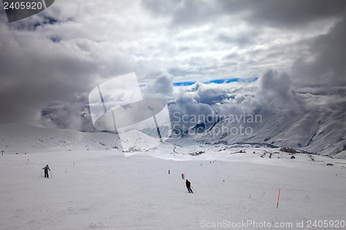 Image of Skiers on ski slope before storm