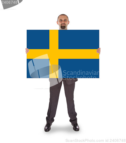Image of Smiling businessman holding a big card, flag of Sweden