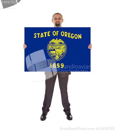 Image of Smiling businessman holding a big card, flag of Oregon