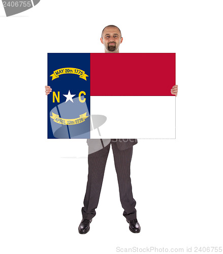 Image of Smiling businessman holding a big card, flag of North Carolina