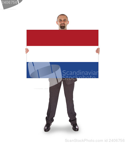 Image of Smiling businessman holding a big card, flag of the Netherlands