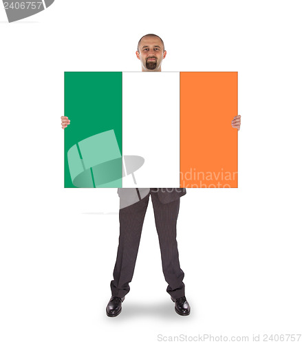 Image of Smiling businessman holding a big card, flag of Ireland