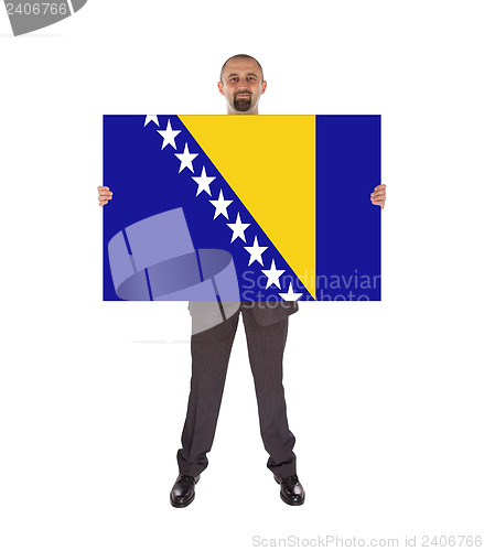Image of Smiling businessman holding a big card, flag of Bosnia and Herze