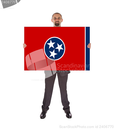 Image of Smiling businessman holding a big card, flag of Tennessee