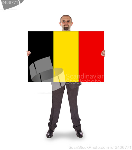 Image of Smiling businessman holding a big card, flag of Belgium