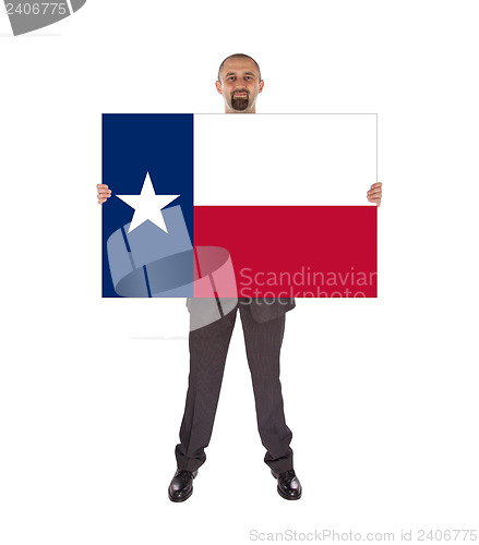 Image of Smiling businessman holding a big card, flag of Texas
