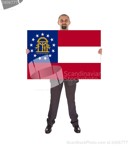 Image of Smiling businessman holding a big card, flag of Georgia