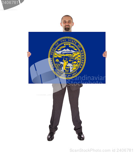 Image of Smiling businessman holding a big card, flag of Nebraska