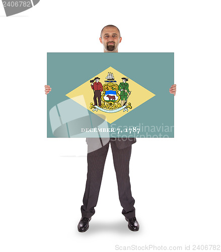 Image of Smiling businessman holding a big card, flag of Delaware