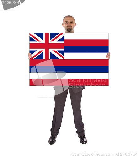 Image of Smiling businessman holding a big card, flag of Hawaii