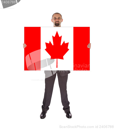 Image of Smiling businessman holding a big card, flag of Canada