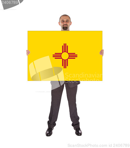 Image of Smiling businessman holding a big card, flag of New Mexico