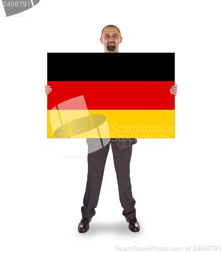 Image of Smiling businessman holding a big card, flag of Germany