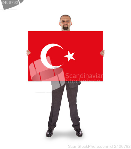 Image of Smiling businessman holding a big card, flag of Turey