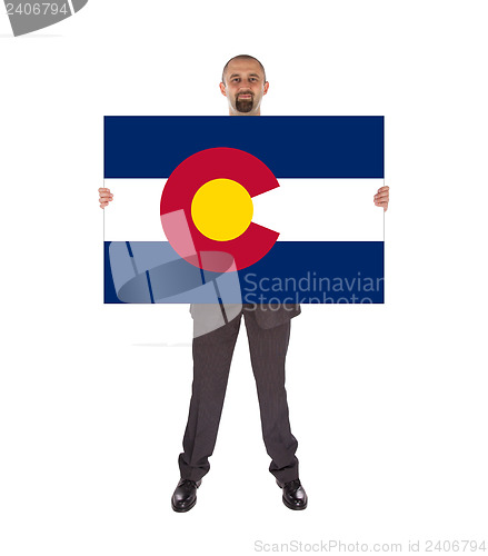 Image of Smiling businessman holding a big card, flag of Colorado