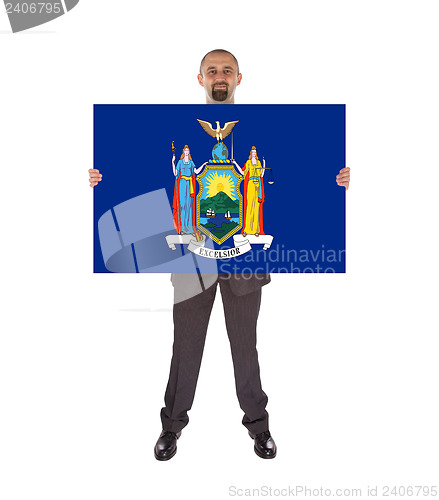 Image of Smiling businessman holding a big card, flag of New York