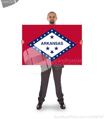 Image of Smiling businessman holding a big card, flag of Arkansas