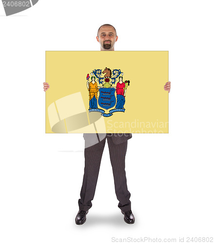 Image of Smiling businessman holding a big card, flag of New Jersey