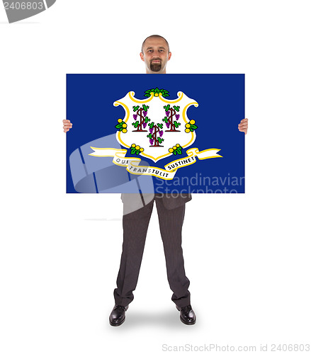 Image of Smiling businessman holding a big card, flag of Connecticut