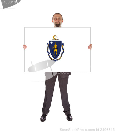 Image of Smiling businessman holding a big card, flag of Massachusetts