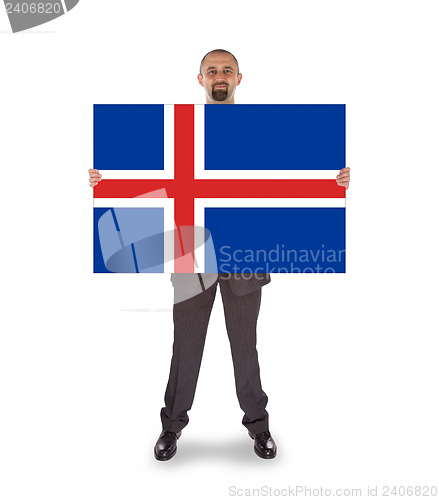 Image of Smiling businessman holding a big card, flag of Iceland